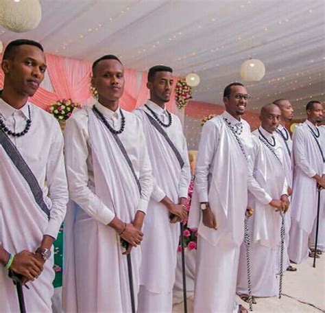 Rwandan Groom And Groomsmen In White Mushanana Attire With Beads A