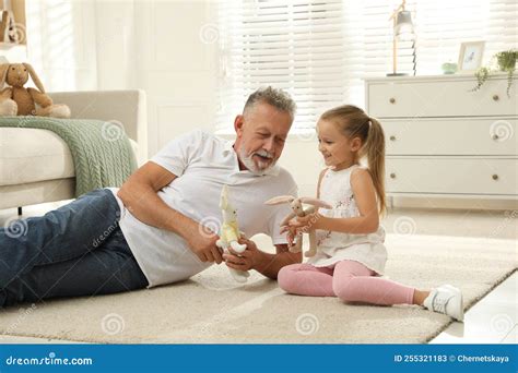 Happy Grandfather And His Granddaughter Playing With Toys Together At