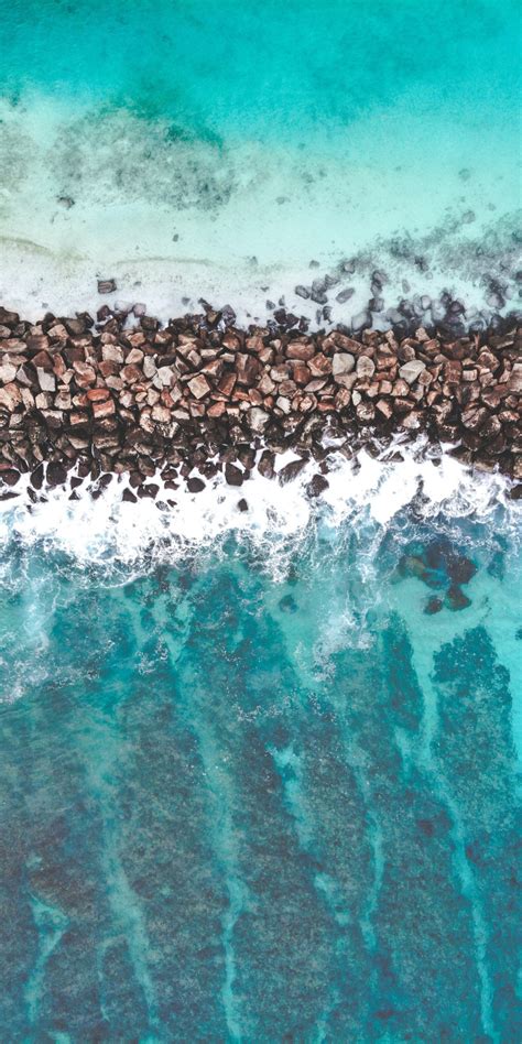Download 1080x2160 Wallpaper Rocks Divider Heap Coast Sea Aerial
