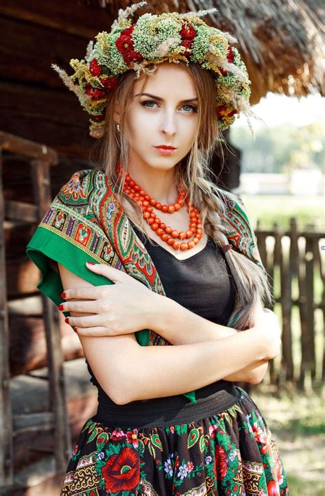 A Woman Wearing A Floral Headdress Is Posing With Her Arms Crossed And