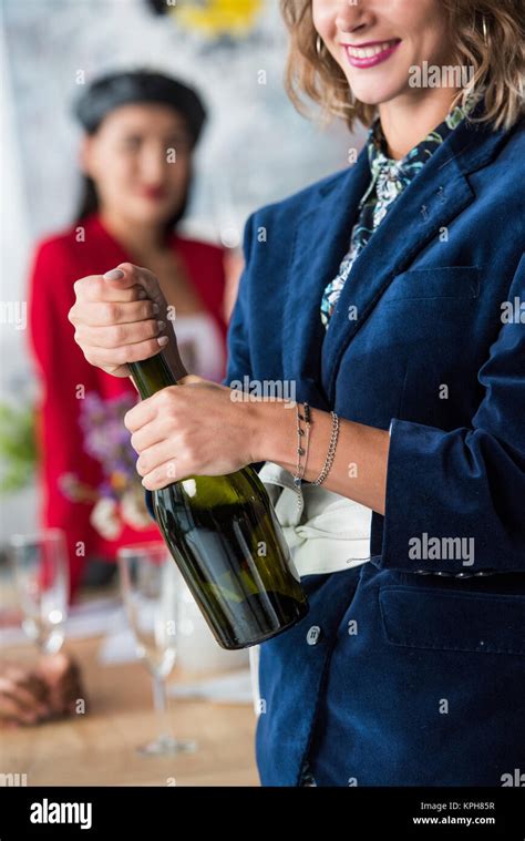 Woman Opening Champagne Bottle Stock Photo Alamy
