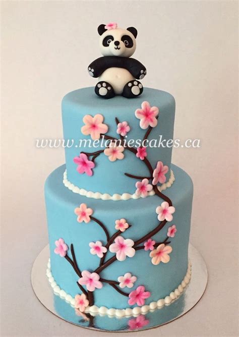 A Three Tiered Cake Decorated With Flowers And A Panda Sitting On Top Of It
