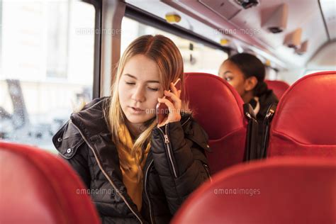 Teenage Girl Talking On Smart Phone While Sitting In Bus 11081036336 の