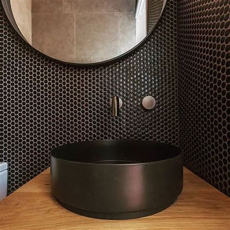 A Bathroom With A Round Sink And Black Wallpaper On The Walls In Front Of A Circular Mirror