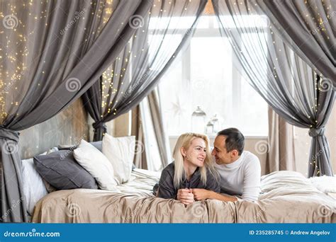 Cheerful Couple Awaking And Looking At Each Other In Bed Stock Image