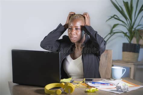 Stressed Black Female Entrepreneur Reading Papers And Working On Laptop