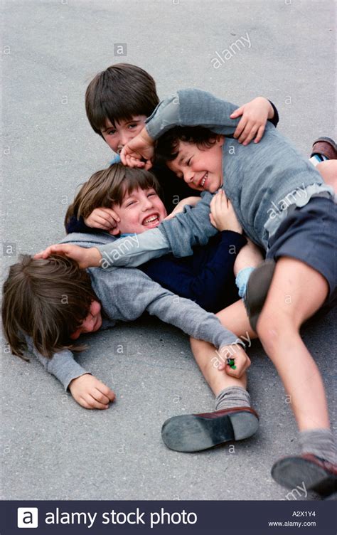 Four School Boys Outside In Playground Enjoying Play