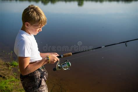 Photo Of A Young Boy Fishing Outdoors On A Summer Day Stock Photo