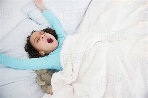African American Girl Waking Up In Bed Stock Photo Dissolve