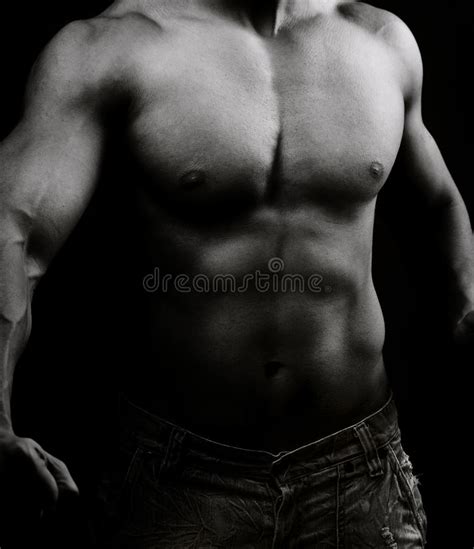 Torso Del Hombre Descamisado Muscular En La Obscuridad Foto De Archivo