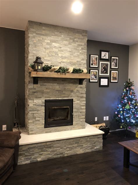 A Living Room With A Christmas Tree In The Corner And Pictures Hanging