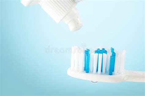 Toothpaste Squeezed From Tube Onto Brush On A Blue Background Close Up