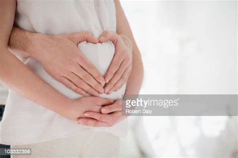 Husband Forming Heartshape On Pregnant Wifes Stomach Bildbanksbilder