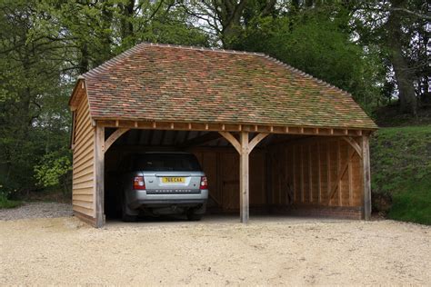 Open sides of an oak car port make the beautiful solid oak frame more visible, embracing the raw beauty of traditional oak beams and braces. Wooden Carport Kits