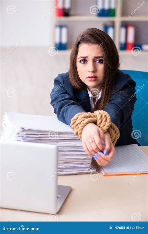 The Young Beautiful Employee Tied Up With Rope In The Office Stock