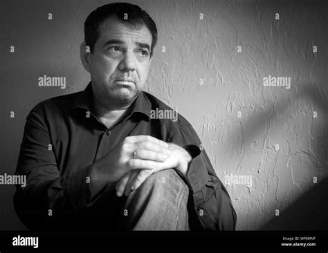 Sad Mature Man Sitting Against Wall Stock Photo Alamy