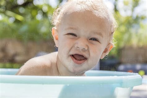 Boy Sitting In Baby Bathtub Stock Photo