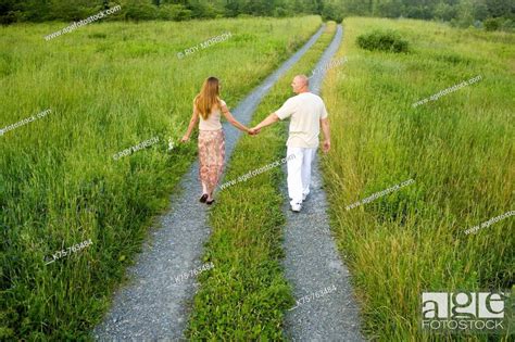 Couple Holding Hands Walking Down Country Road Stock Photo Picture