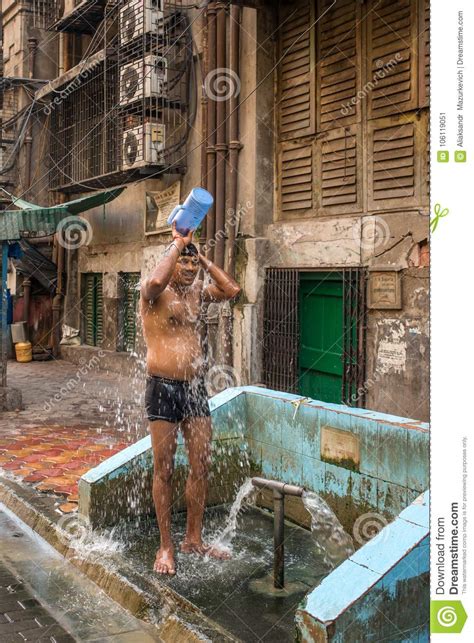 Indian Man Taking Shower From Bucket On Streets Of Mumbai India