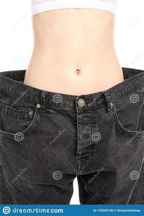 Woman Shows Her Weight Loss By Wearing An Old Jeans Stock Photo Image