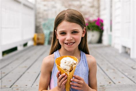 Treat Young Girl Holds Waffle Cone With Ice Cream By Stocksy