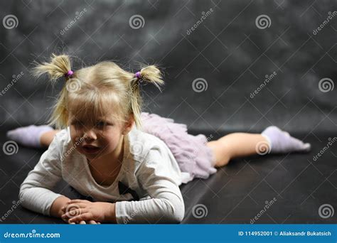 Child Girl Upset Lying On The Floor And Crying On A Black Background