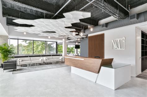 An Office Lobby With White Walls And Wood Accents On The Ceiling Along