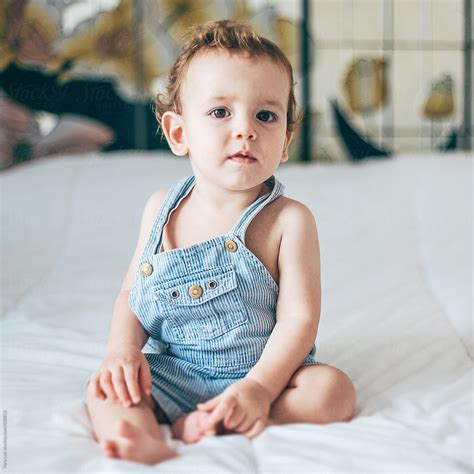 Portrait Of A Baby Boy Sitting On A Bed Del Colaborador De Stocksy