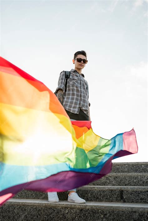 bandera arcoiris en mano de homosexual foto gratis