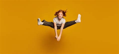 Have A Fun Happy Little Girl Kid In White T Shirt And Jeans Jumping