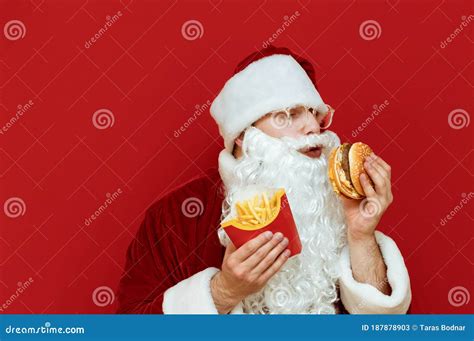Hungry Santa Claus Isolated On Red Background With Burger And French