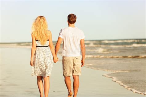 Young Couple Holding Hands Walking Away Together Photo