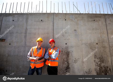 Structural Engineer And Architect Dressed In Orange Work Vests And