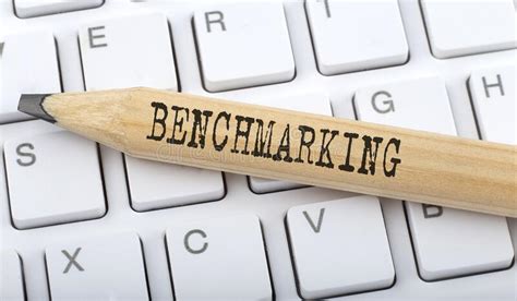 Text Benchmarking On Wooden Pencil On White Keyboard Business Concept