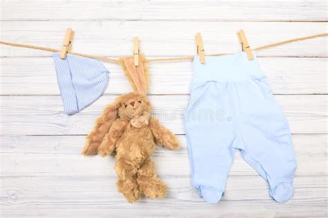 Baby Clothes And Toy Bunny On A Clothesline On Wooden Background
