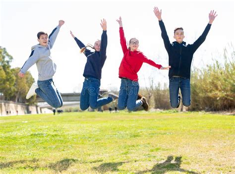 Happy Teenagers Jumping On The Green Lawn Stock Image Image Of Meadow