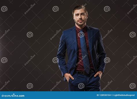 Handsome Businessman In Stylish Suit Standing With Hands In Pockets And