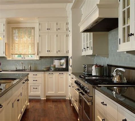 Beautiful cream colored kitchen with brown walls and marble backsplash. Perfect kitchen color scheme. Dark granite and cream cabinets with light blue subway tile ...