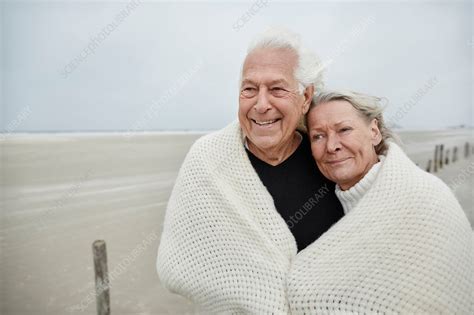 Senior Couple Wrapped In A Blanket On Beach Stock Image F0181913