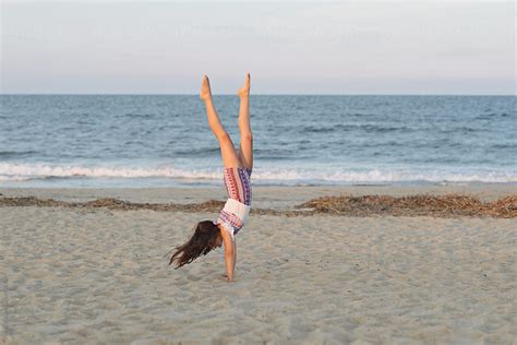 Young Girl Doing Handstand On The Beach By Stocksy Contributor