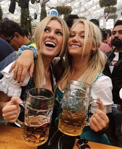 two women are smiling and holding beer mugs