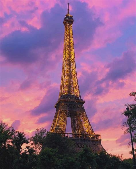 Eiffel Tower At Sunset With Pink And Purple Sky The Tower Is Lit With