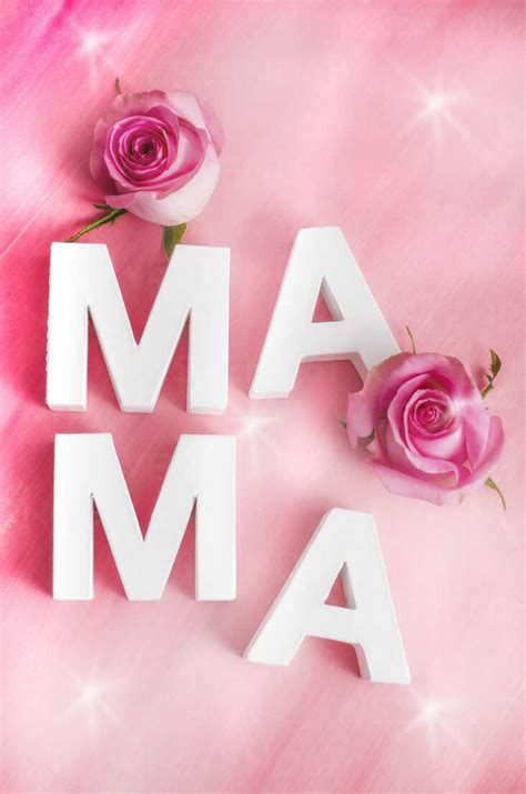 Two Rose Blossoms And White Letters Building The Word Mama On Pink
