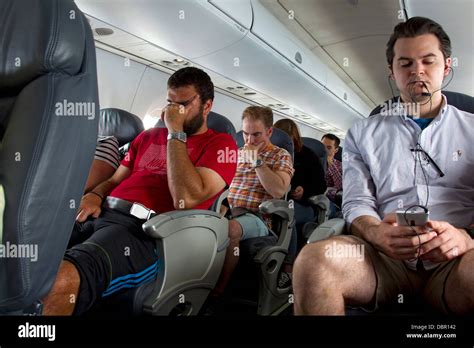 Passengers Aboard Commercial Airline Flight Sitting In Airplane