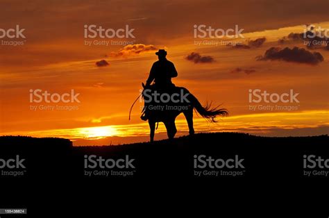 Cowboy Rides Into The Sunset Stock Photo Download Image Now Cowboy
