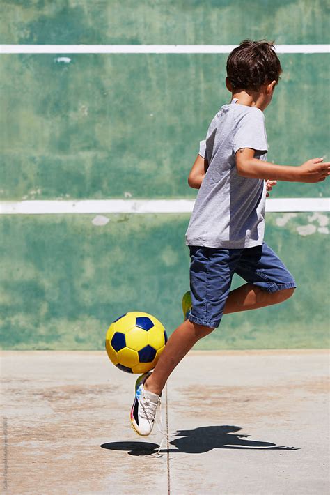 Unrecognizable Boy Playing Football On Asphalt by Guille Faingold ...