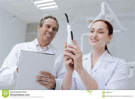 Positive Delighted Medical Workers Examining New Instrument Stock Image