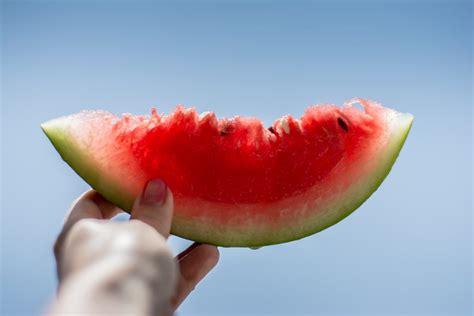 Free Photo Woman Holding Juicy Slice Of Watermelon In Her