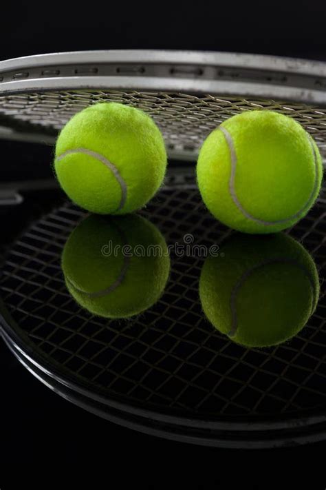 Close Up Of Fluorescent Yellow Tennis Balls With Racket With Reflection