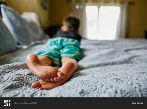 Bare Feet Of Boy Lying On Bed Stock Photo Offset